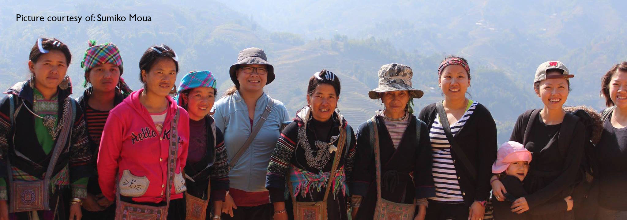 Mai Chao Duddeck, friends, and women of Vietnam pose for a group picture in front of the mountains.
