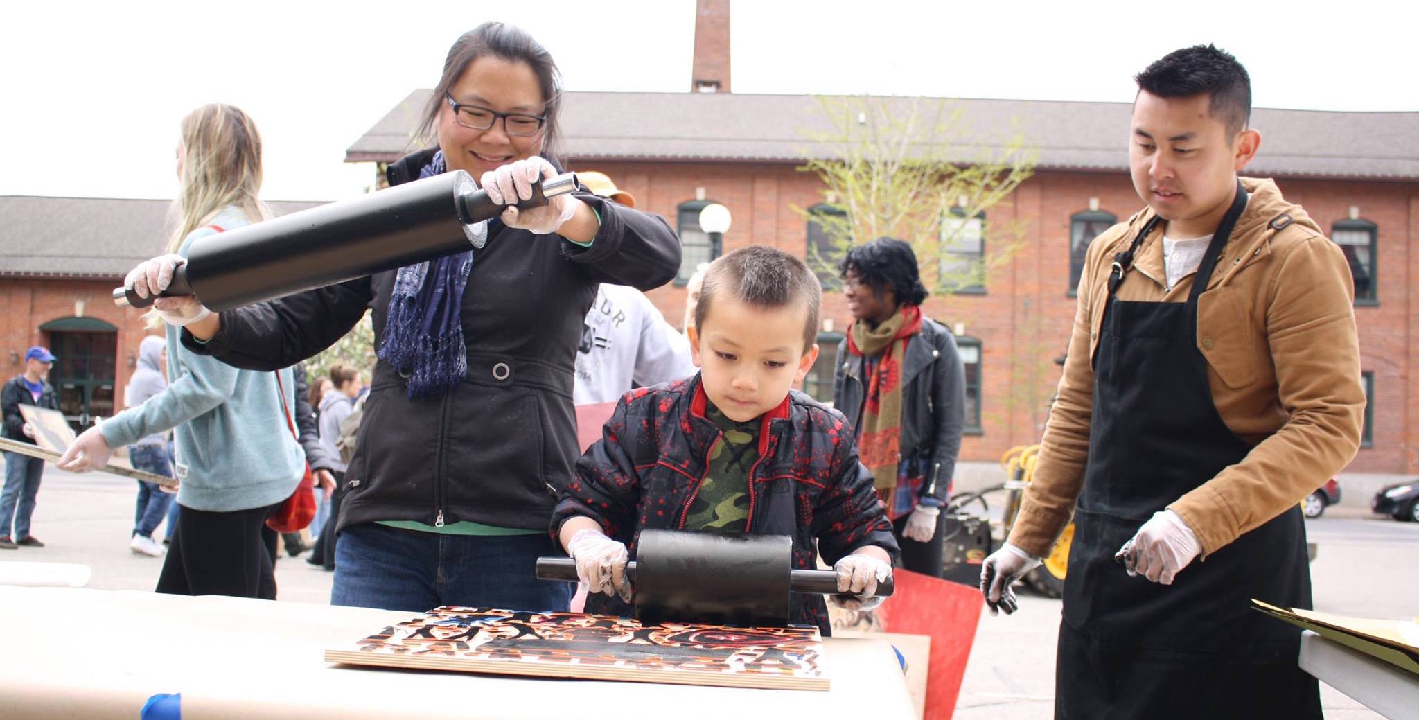 Mai Chao Duddeck and her son, Ari, happily prepare woodcuts for print.